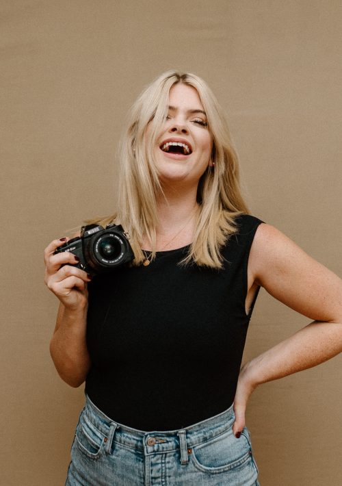 photographer alaina yard of alaina yard photography holds camera and smiles